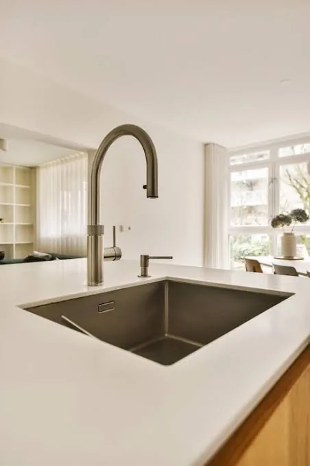 Plumber working on a kitchen sink plumbing connection
